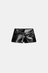 Shorts de tiro medio con efecto de cuero brillante en color negro, con cierre frontal y detalles de botones en la cintura.