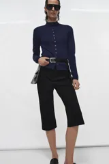 Cinturón ancho de cuero negro con hebilla metálica cuadrada dorada. Incluye dos faldones laterales con bolsillos parche abultados y solapa.