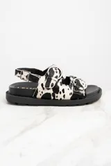 Sandalias con plataforma de goma negra y tiras de pelo de vaca con hebillas plateadas.