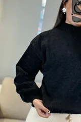 Buzo de chenille color marrón, con cuello alto, mangas largas con puños ajustados y ruedo acanalado.