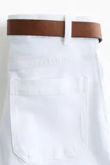 Pantalón acampanado de sarga de algodón color blanco, de tiro alto con pliegues en las piernas y bolsillos decorativos delanteros. Incluye cinturón marrón.