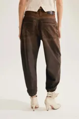 Jean slouchy marrón de tiro alto con silueta barrel relajada que se estrecha hacia los tobillos y textura de cuadros sutil.