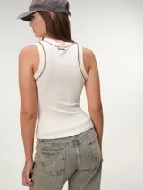 Musculosa de tela rib color marfil, con escote nadador, corte ajustado al cuerpo y costuras a contratono en color marrón.