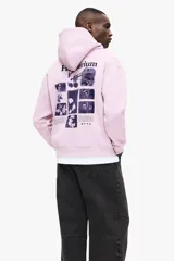 Canguro de algodón con capucha y cordones ajustables, diseño de hombros caídos y bolsillo frontal tipo canguro. Presenta un estampado gráfico en el pecho y puños acanalados.