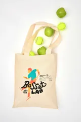 Tote bag de lienzo color crudo con estampa de un tenista y el logo de Basset Lab.