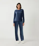 Conjunto de pijama largo de plush azul oscuro, compuesto por una blusa de manga larga con cuello redondo y bordado de lettering en blanco, y un pantalón largo de corte recto.
