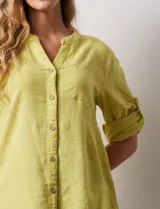 Blusa color verde claro de lino marca Cupio, con cuello a la base, escote en V y abertura con botones. Tiene un bolsillo en la parte delantera y mangas 3/4 regulables con presilla y botón.