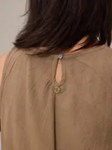 Vestido largo sin mangas de corte holgado, con cuello redondo y bolsillos laterales. Confeccionado en una mezcla de algodón y lino en color marrón.