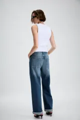 Jeans de tiro medio con diseño de cinco bolsillos, pernera holgada y bajo con vuelta. Cierre frontal con cremallera y botón.