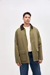 Campera de gabardina color marrón con cuello de pana en tono oscuro. Presenta cierre frontal con botones a presión, bolsillos laterales con solapa y diseño de calce clásico.