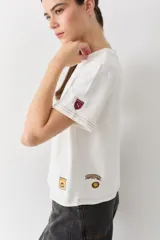 Remera de cuello redondo y manga corta en color blanco, con costuras a contratono y logo de la marca estampado en el pecho.