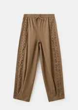 Pantalón marrón de corte recto, con cintura ajustable elastizada y cordón, y detalle de franja lateral bordada con diseño calado.