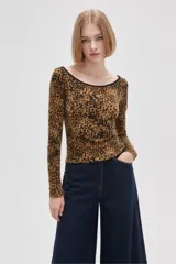 Remera de manga larga con cuello bote, confeccionada en tejido con estampado animal print. Presenta un ajuste al cuerpo y un borde en color negro en el escote.