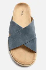 Sandalia plana color beige con dos tiras anchas cruzadas en el empeine, plantilla anatómica y suela forrada en yute.