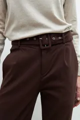 Pantalón de vestir marrón chocolate con cinturón de cuero a tono.