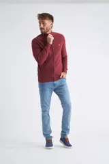 Campera tejida en punto buttoné color bordó, con cierre frontal completo, cuello levemente elevado y logo bordado en el pecho.