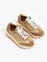 Zapatilla Mumi de cuero vacuno flor y descarne, color gris claro y celeste, con bordado "JCH" en el lateral. La base es de caucho para mayor liviandad y confort. Incluye cordón de algodón.