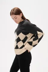 Sweater de tejido jacquard con diseño de rombos en colores azul marino y rojo, de corte holgado, manga larga y cuello redondo.