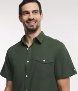 Camisa de hombre de manga corta color marrón, confeccionada en lino y algodón. Presenta cuello clásico, botonadura frontal, bolsillo en el pecho y mangas con botón para enrollar.