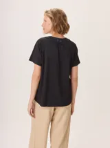Remera de manga corta con cuello redondo y abertura frontal en V, confeccionada en una combinación de tejido de algodón con lurex y detalles en lino.