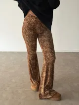 Pantalón tipo oxford de tiro alto con estampado animal print de leopardo, corte ajustado en la parte superior y acampanado desde la rodilla hacia abajo.