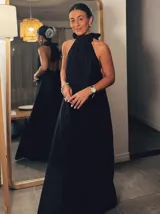 Mono largo negro con cuello halter y corte palazzo. Incluye un collar plateado con dije de hueso.