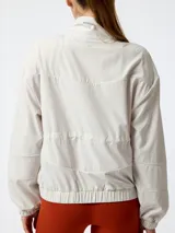 Campera cortavientos Bsoul color blanco, con cierre frontal, cordón ajustable en la cintura y puños elásticos.