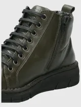 Botines de cuero color verde oliva con cordones negros, suela de poliuretano negra y diseño de caña baja.