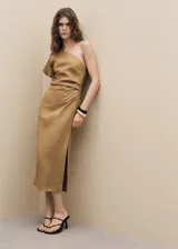 Vestido midi de lino color tostado, con diseño asimétrico de un solo hombro, manga corta y cintura drapeada con abertura lateral en el bajo.