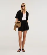 Short negro de mujer, modelo runner evasé, confeccionado en viscolino. Presenta cintura elástica con botón y bolsillos laterales.