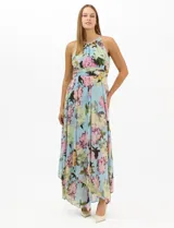 Vestido largo de chifón con estampado floral, cuello halter con pliegues y abertura tipo lágrima. Presenta una cintura drapeada que estiliza la silueta y una falda amplia con capas asimétricas y bajo en picos. Incluye forro interior y cierre invisible en la espalda.