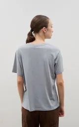 Remera de algodón de corte clásico y cuello redondo, color negro con estampa frontal en color azul que representa montañas y un esquiador con la inscripción Ski Festival.