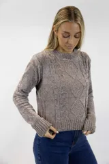 Buzo tejido de chenille blanco con cuello redondo, mangas largas, terminaciones acanaladas y diseño frontal con detalles de trenzas y texturas combinadas.