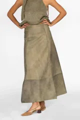 Pollera midi de cuero con diseño de paneles verticales y costuras decorativas visibles. Presenta un corte acampanado y un acabado con efecto desgastado en tonos tierra.