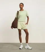 Bermuda deportiva verde claro de modal, con cintura elástica y frisos contrastantes en los laterales.