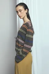 Cardigan de punto marrón con escote en V y cierre frontal con tiras para atar. Presenta diseño de rayas horizontales con patrón en zigzag de colores vibrantes como naranja, verde lima, azul y rosado.