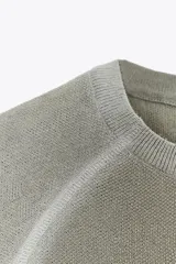 Top de punto gris claro con cuello redondo y manga corta, presentando un efecto degradado o desteñido en el cuello, hombros y ruedo.