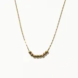 Collar dorado con cadena fina y siete dijes esféricos.