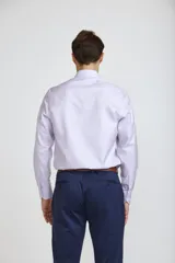 Camisa de vestir blanca de corte clásico, con cuello rígido, cierre frontal de botones y mangas largas con puños abotonados.