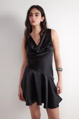 Vestido corto negro de acabado satinado tipo gloss, sin mangas, con escote drapeado y falda evasé con corte asimétrico.