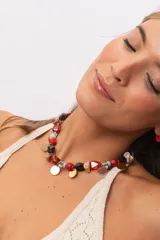 Collar corto de piedras naturales, cuentas de madera y dijes metálicos colgantes en tonos dorados y plateados.