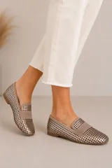 Mocasines chatos de cuero vacuno en color celeste, con diseño calado en toda la superficie y detalle de tira lisa en el empeine. Poseen suela plana y taco bajo de goma.