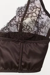 Bralette de diseño combinado en tejido satinado y encaje floral a tono. Presenta escote en pico, tirantes finos ajustables y cierre posterior con ganchos metálicos.
