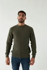 Sweater azul marino de punto con cuello redondo, mangas largas y logo bordado en el pecho.