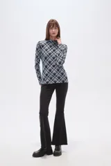 Remera de manga larga con cuello alto, confeccionada en tejido de viscosa y elastano con estampado a cuadros en tonos azul, gris y negro.