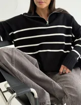 Sweater estilo chomba con cierre frontal, confeccionado en tejido bremer rayado de manga larga. Presenta un diseño amplio y moderno con cuello polo.