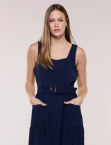 Vestido midi blanco de la marca Nina Leonard, sin mangas y con escote cuadrado. Cuenta con corte en la cintura, bolsillos laterales con solapa, falda fluida con detalle de frunce inferior e incluye un cinturón del mismo género con hebilla carey.