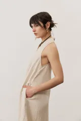 Vestido largo marrón, sin mangas, con cuello halter y bolsillos laterales.