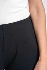 Pantalón negro de corte ancho y relajado, confeccionado en algodón texturizado.