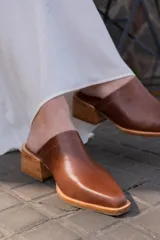 Zuecos de cuero color marrón con punta fina y taco de madera.